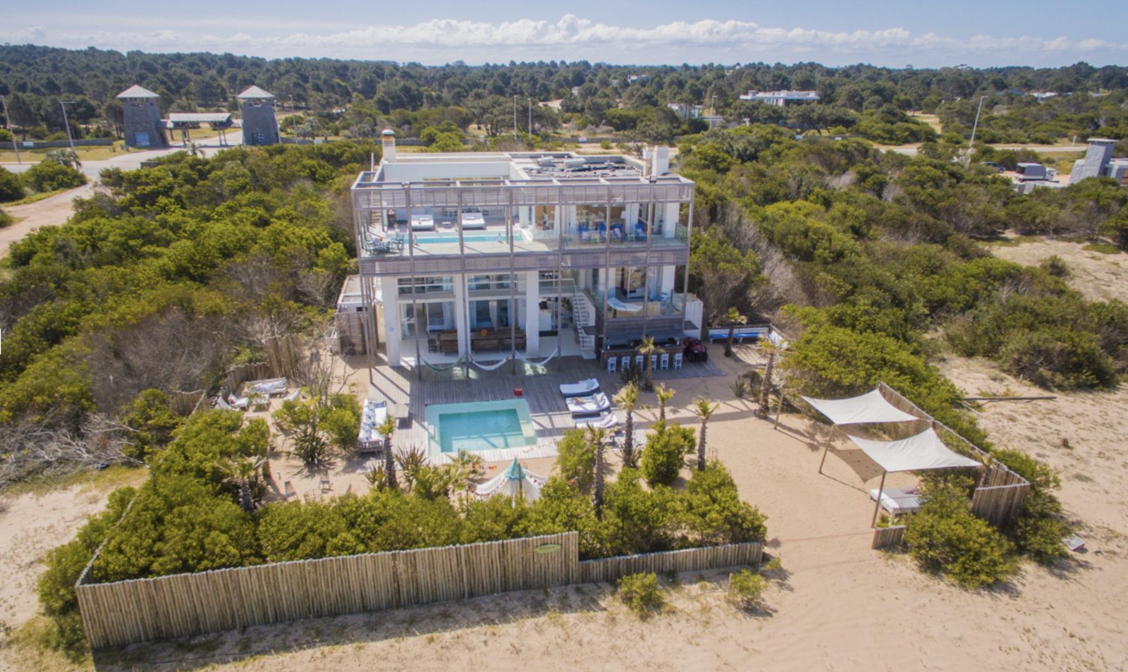 Vista aérea de uma casa de frente para o mar com piscina entre as dunas, no litoral de José Ignacio