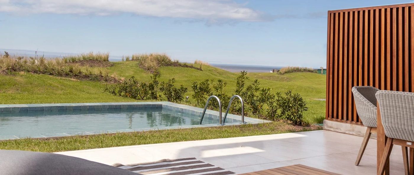 Piscina propia de una unidad de planta baja, con el horizonte de mar al fondo