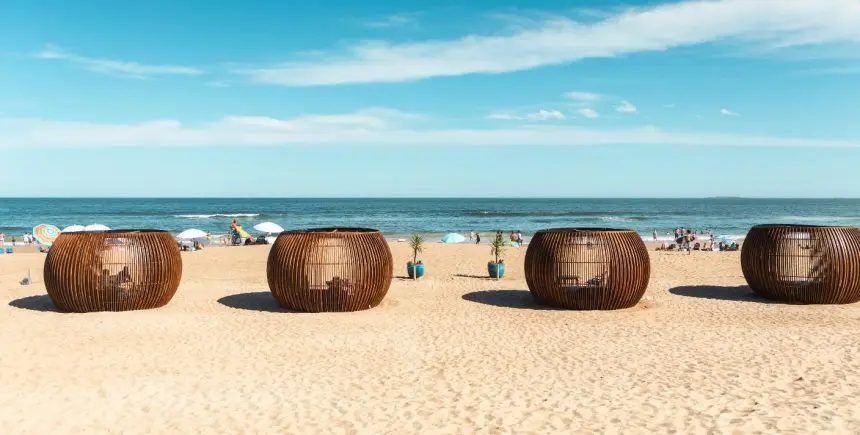 Casillas de mimbre del parador sobre la playa, un día de sol
