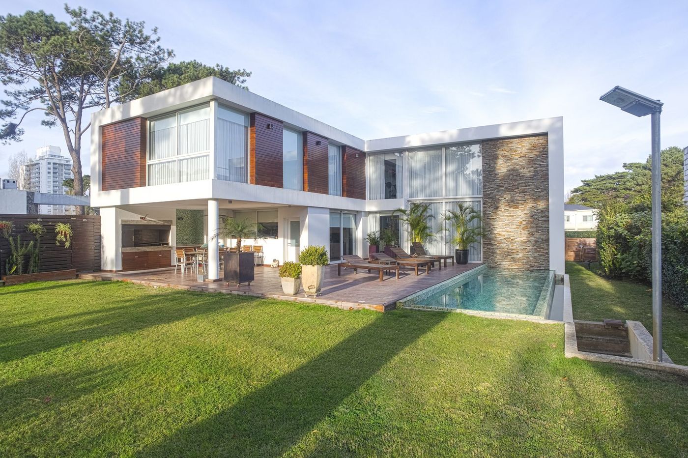 Casa con piscina infinita y parque en Boulevard Park, con una torre de Punta del Este al fondo