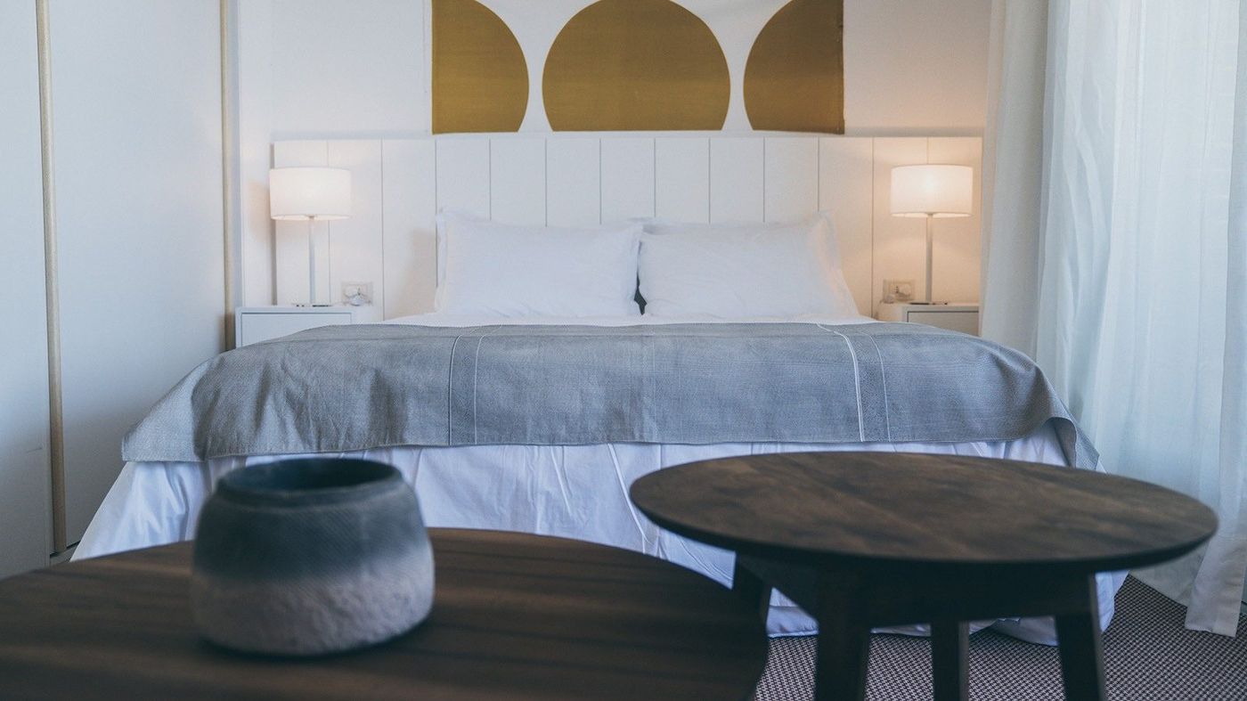 Dormitorio con cabecera blanca y detalles dorados