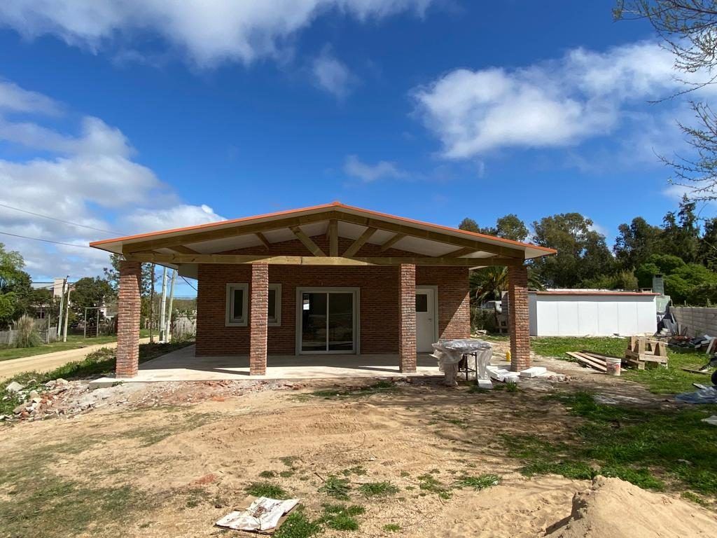Frente de la casa todavía en obra, con materiales apilados