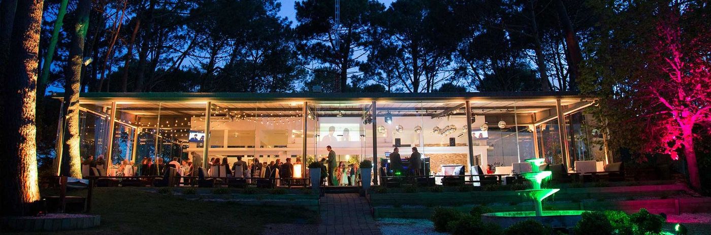 La sede social vidriada de noche, con un evento en marcha