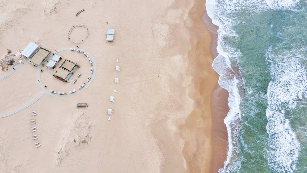 Cenital del chiringuito sobre las dunas, junto a la rompiente