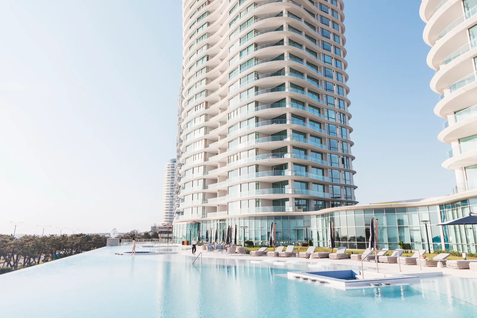 Piscina infinita de Fendi Château con las torres onduladas de fondo en un día soleado