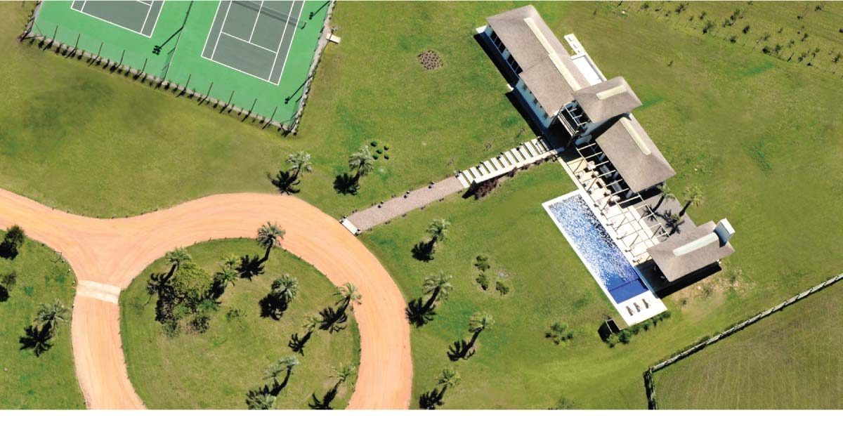 Aérea del club house con las canchas de tenis, la piscina y la caminería