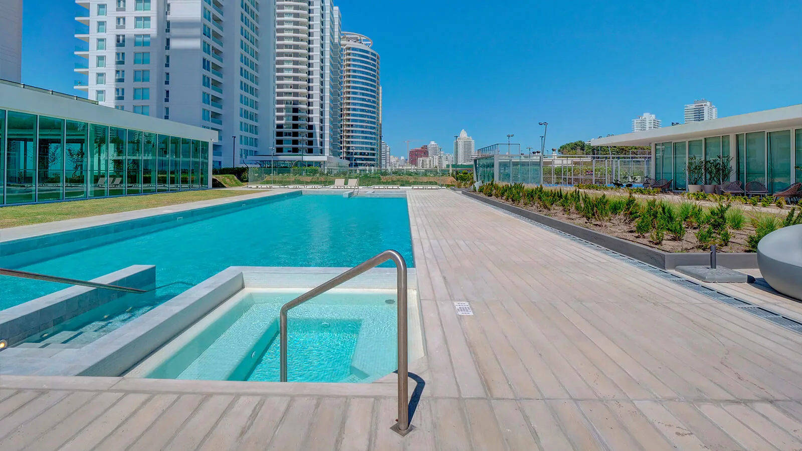 Piscina exterior con jacuzzi, rodeada por las torres