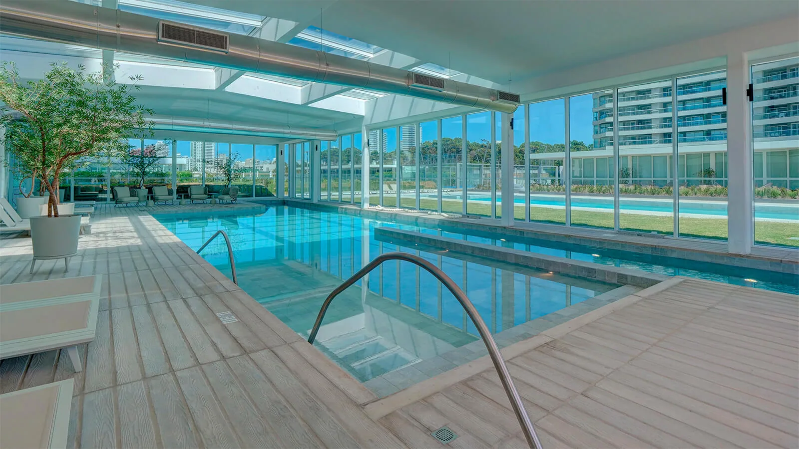 Piscina interior climatizada, vidriada hacia la piscina exterior