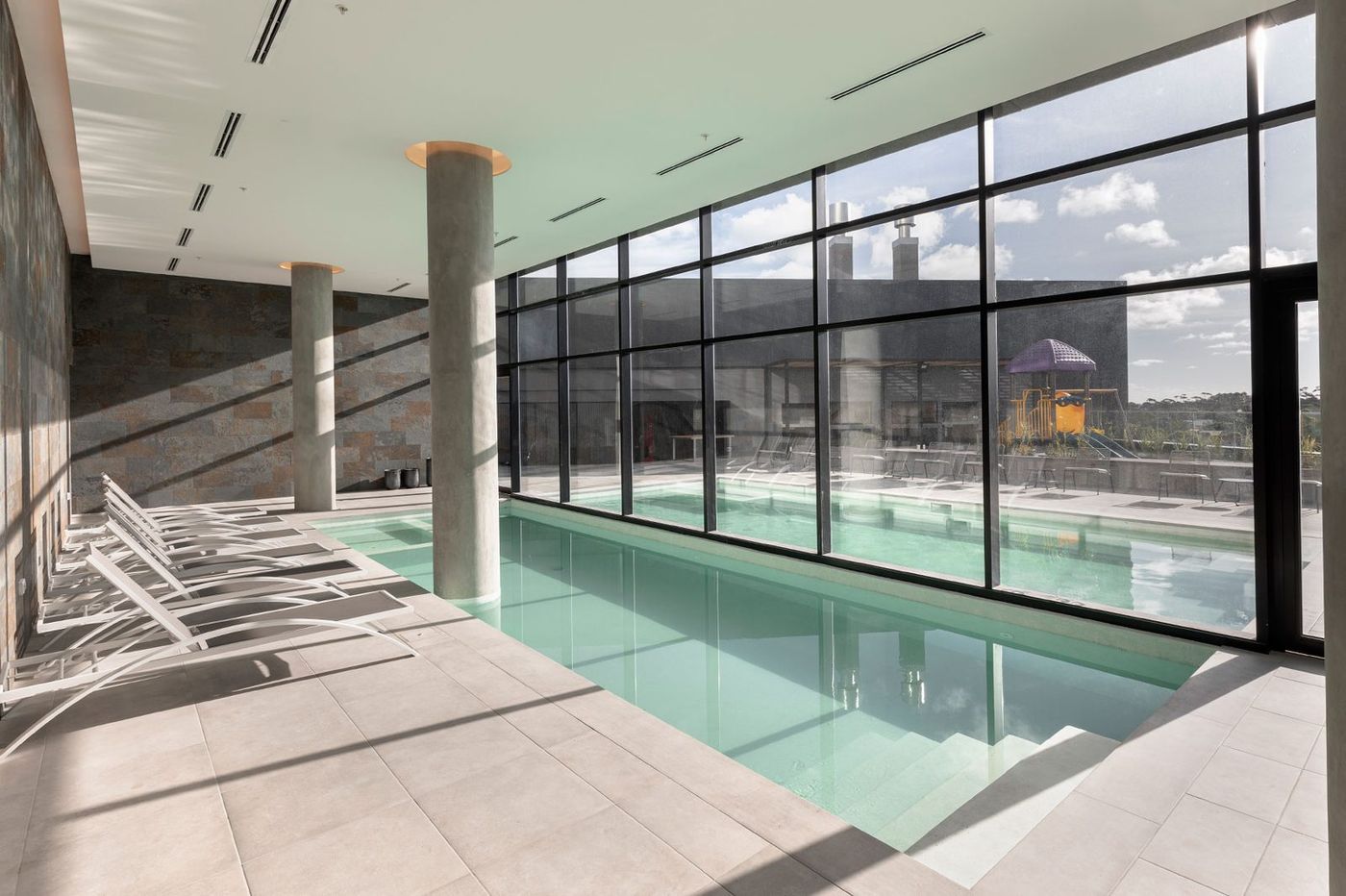Piscina interior climatizada con paño vidriado a la terraza y juegos infantiles