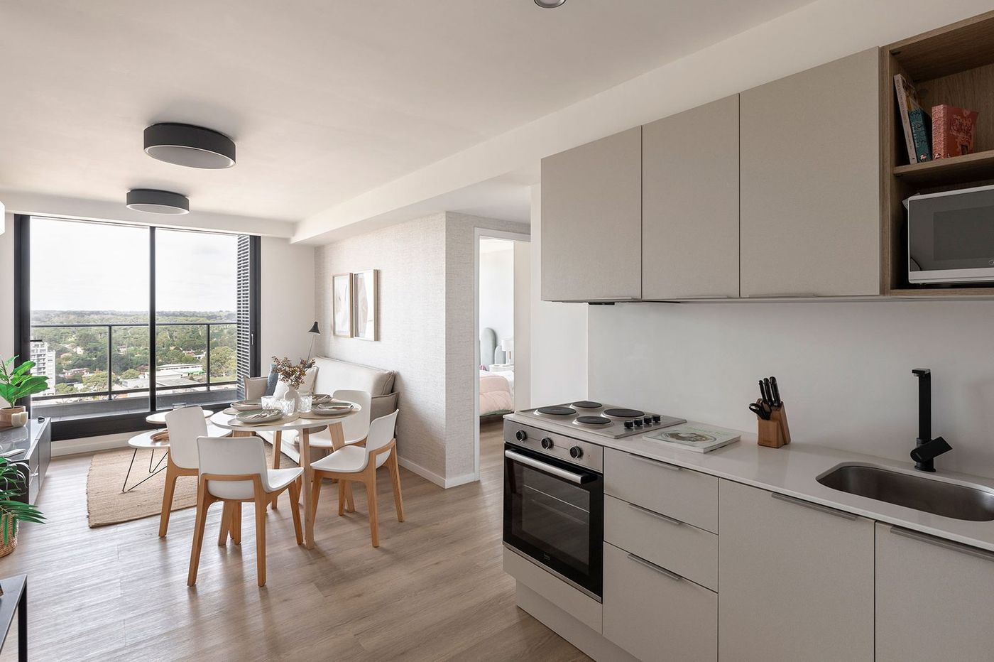 Living comedor y cocina de una unidad, con balcón y vista abierta