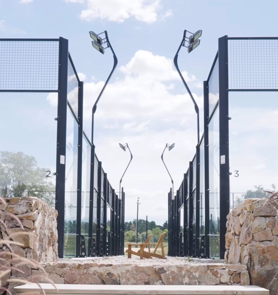 Canchas de pádel iluminadas entre muros de piedra
