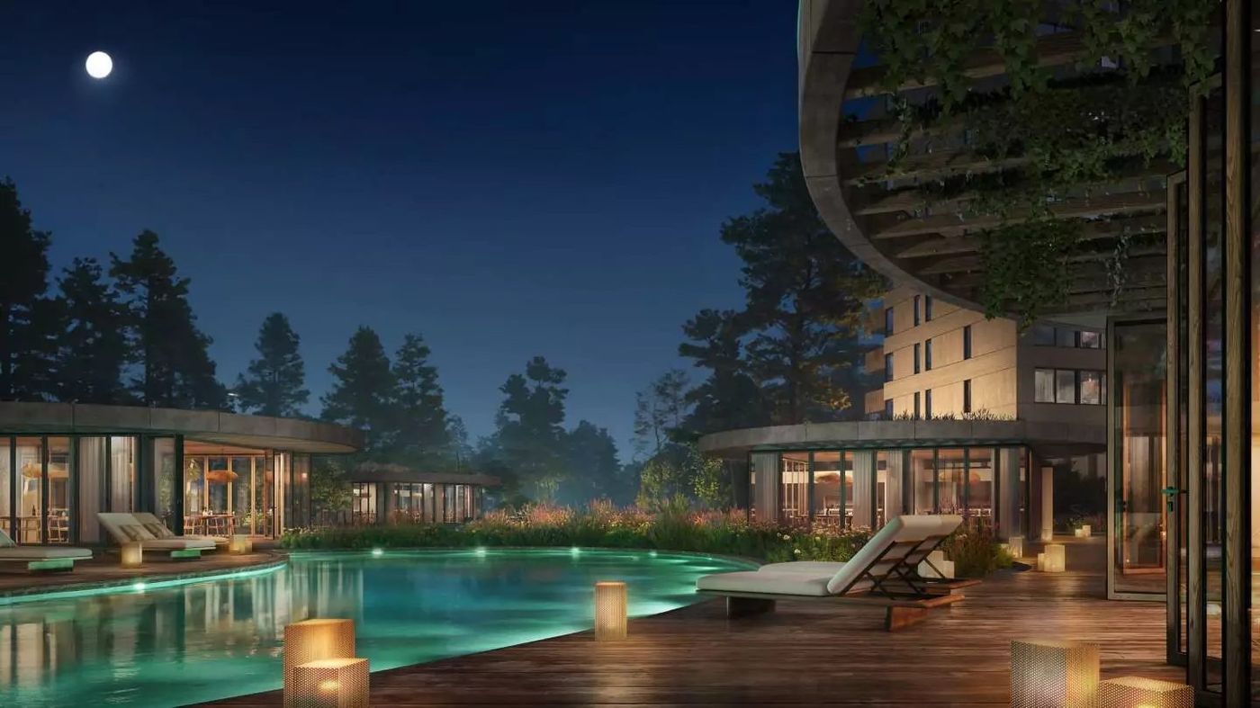 Piscina exterior de noche, entre los pabellones de amenities