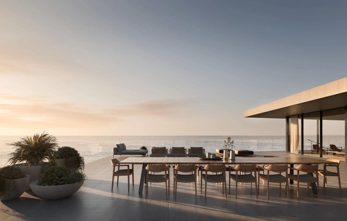 Render de la terraza con mesa larga frente al océano abierto