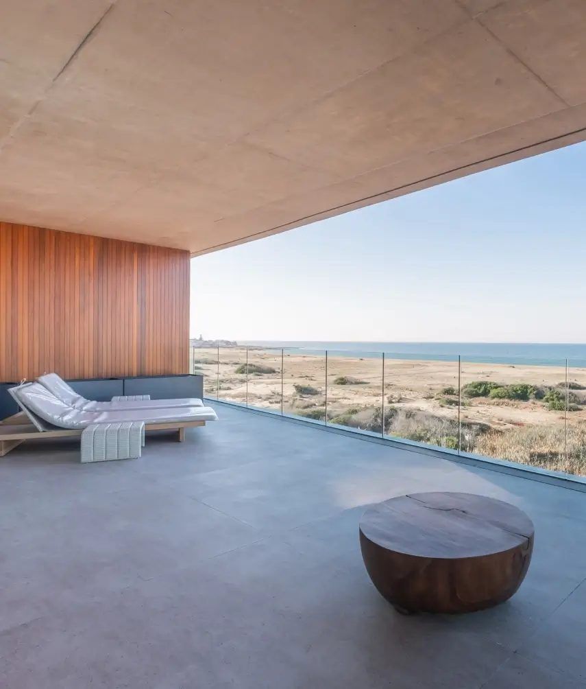 Terraza de una unidad con camastros y vista abierta al océano y al faro