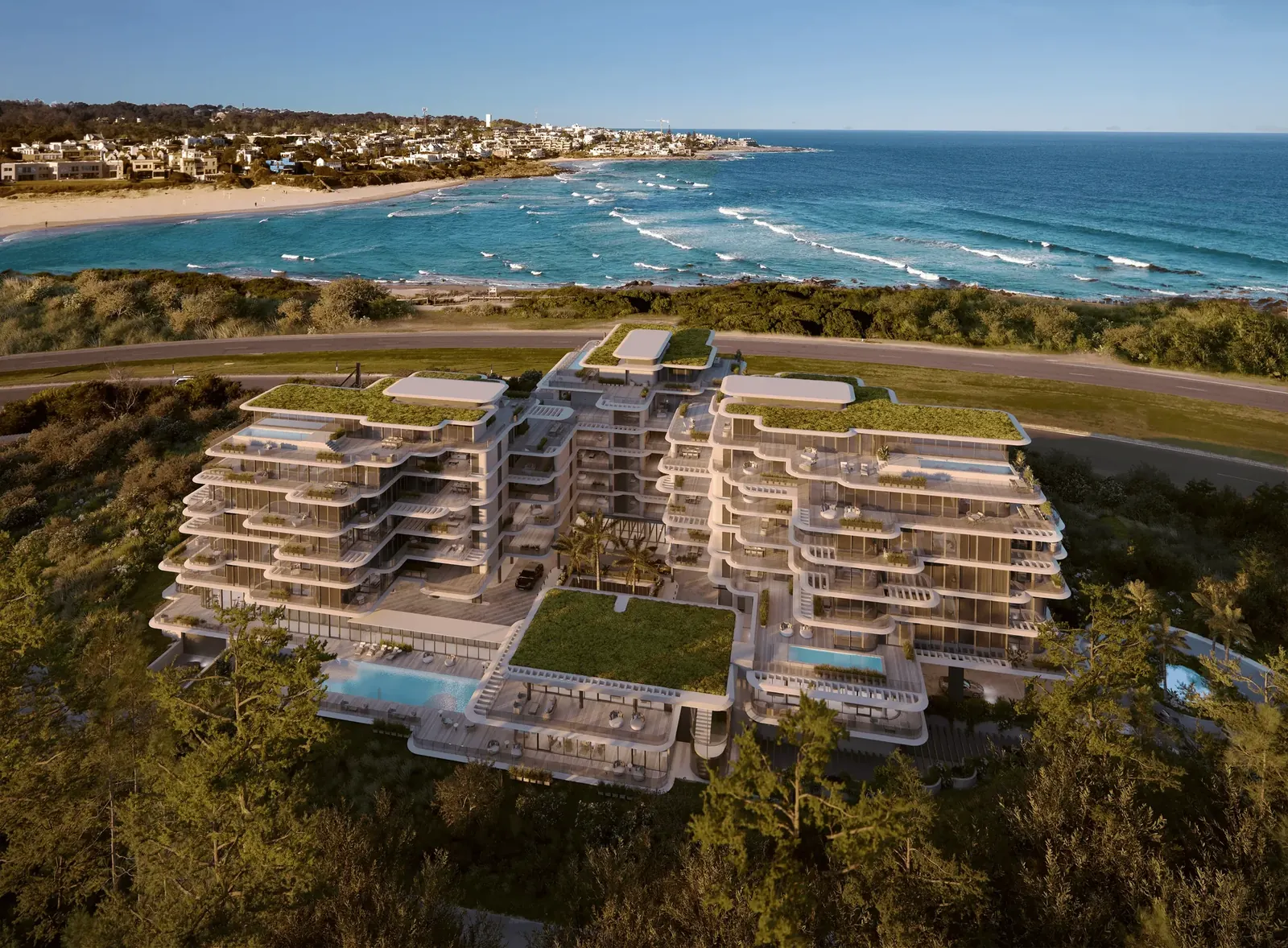 Aérea de The Rock con sus terrazas verdes, las piscinas y la playa Brava detrás