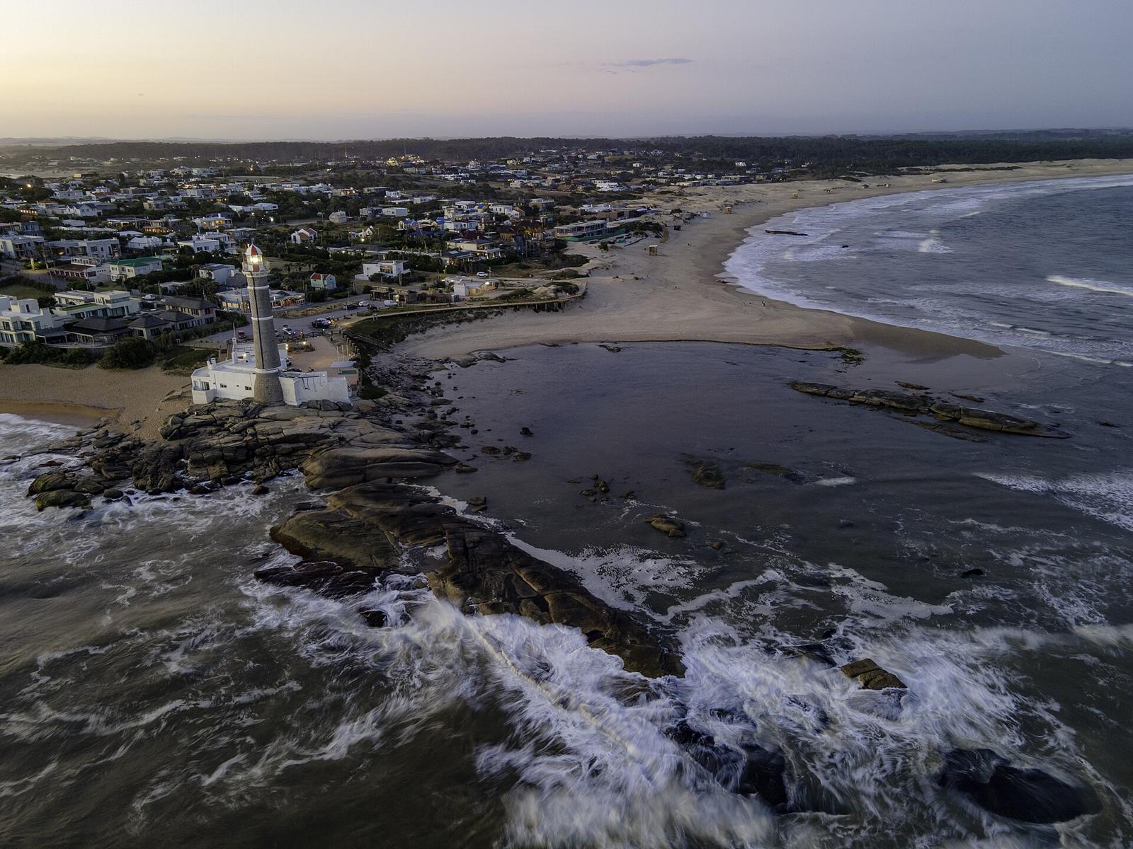 Vista aérea do farol e do povoado de José Ignacio, com a Playa Mansa e a Playa Brava de cada lado