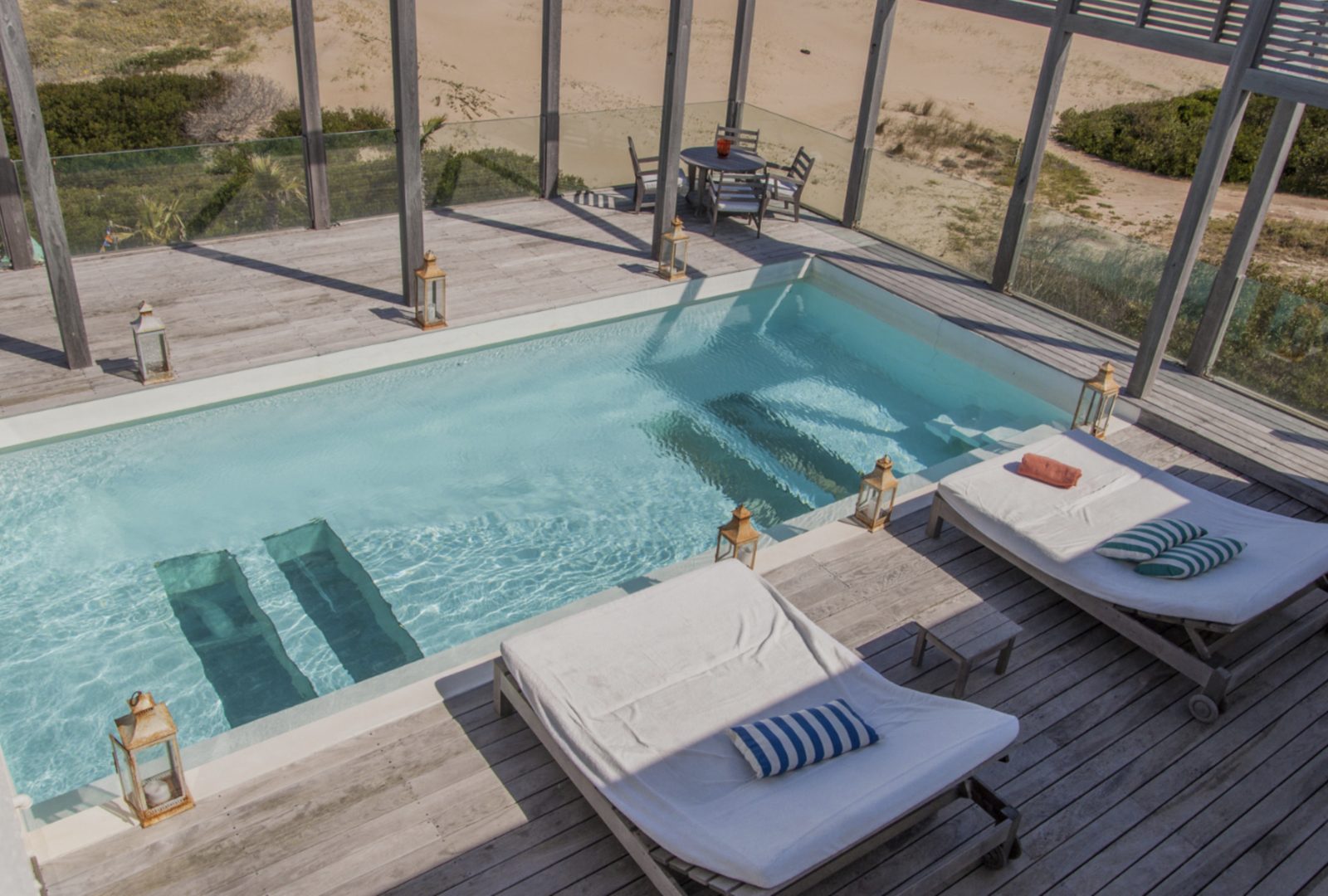 Pool with wooden deck and loungers facing the dunes, José Ignacio