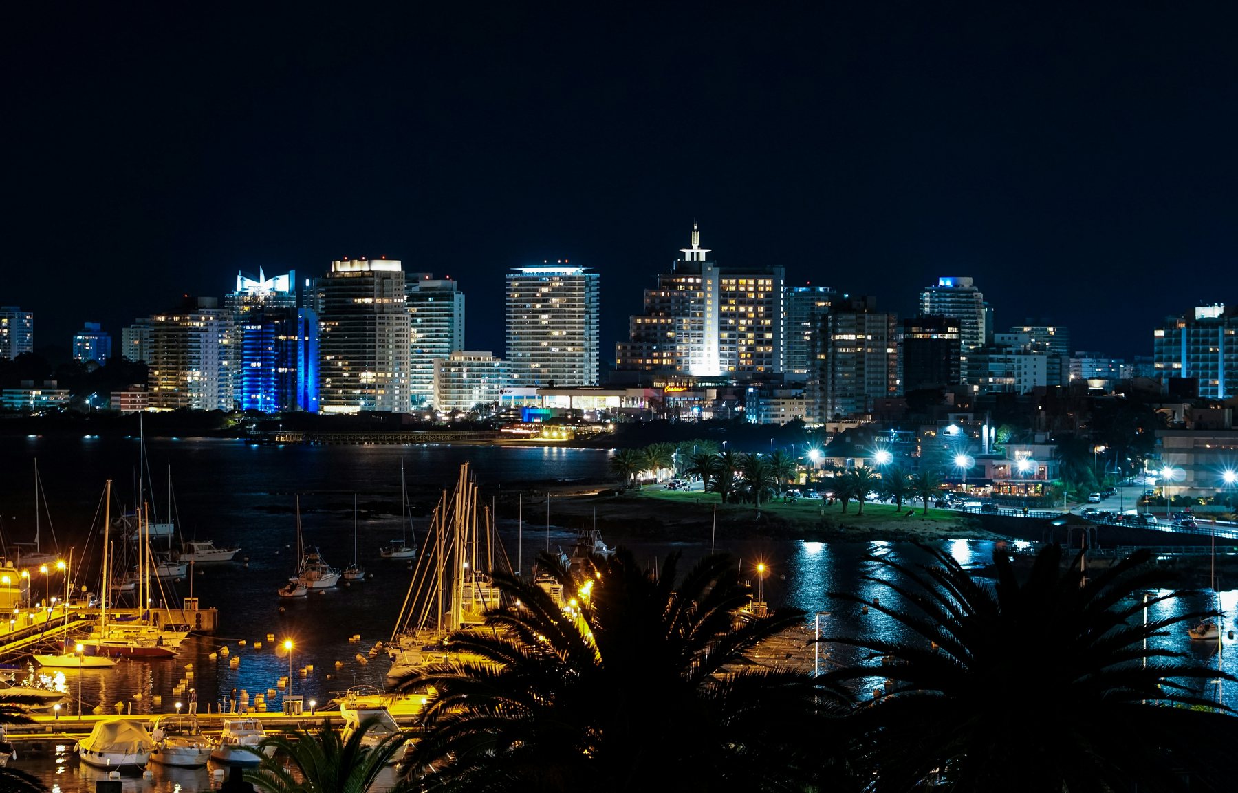 Punta del Este de noche desde el puerto, con el skiline iluminado y los veleros en la marina